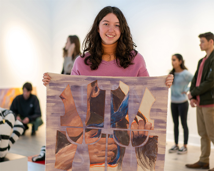 Student holding an art project