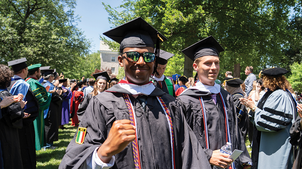 Two students in graduation robes process out of their ceremony